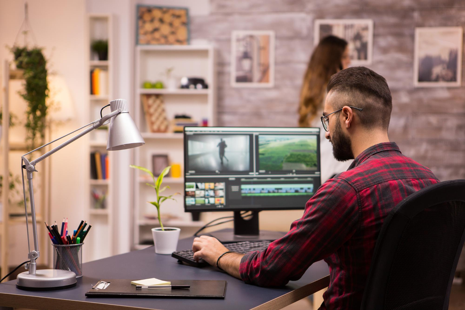 back-view-creative-filmmaker-working-movie-laptop-girlfriend-background